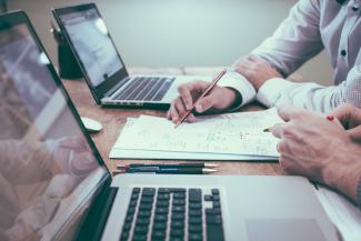 person holding pencil near laptop computer by Scott Graham courtesy of Unsplash.