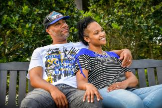 man in white crew neck t-shirt sitting beside woman in black and white stripe shirt by LaShawn Dobbs courtesy of Unsplash.