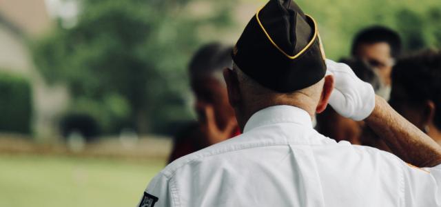 man wearing white uniform saluting by sydney Rae courtesy of Unsplash.